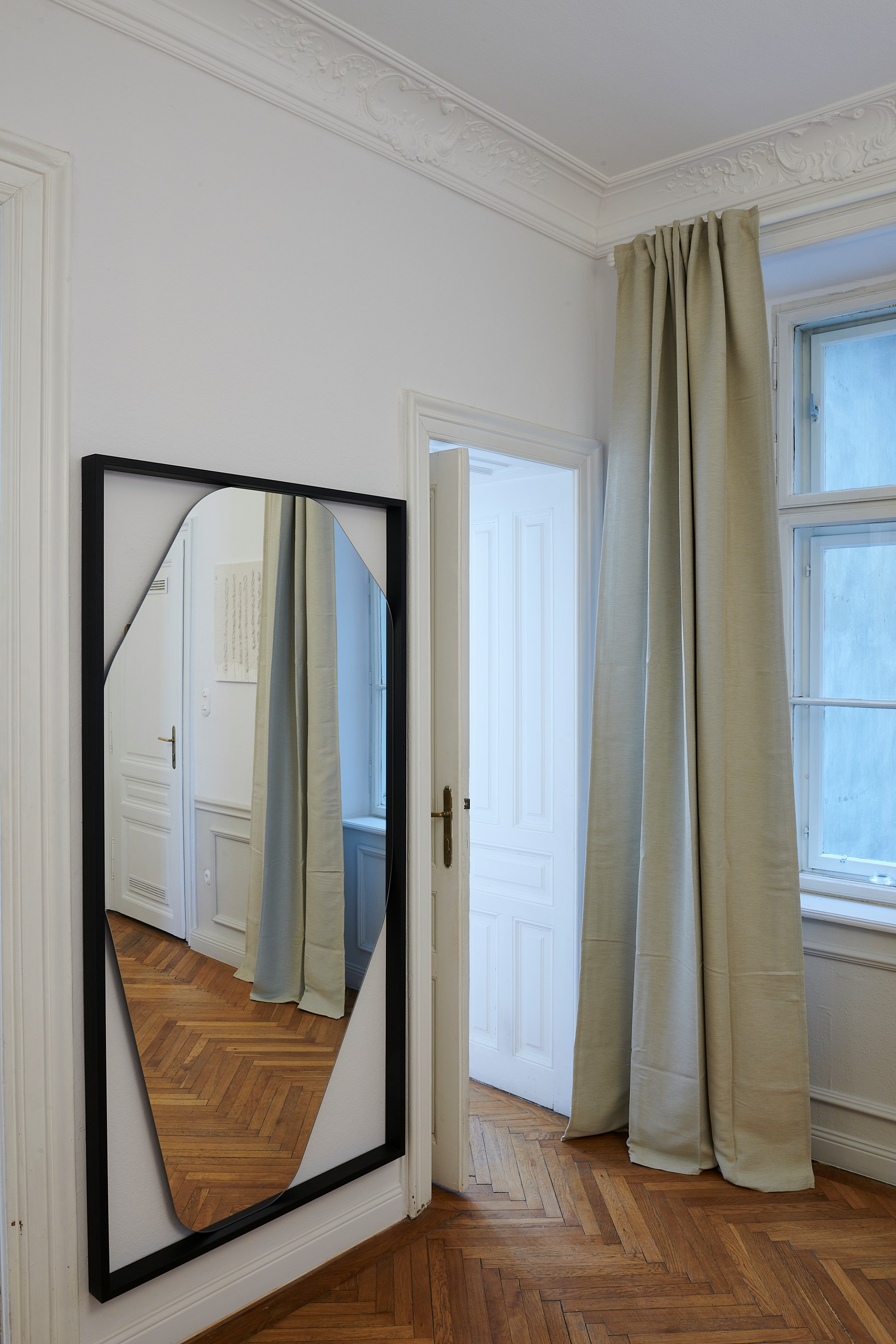 Des moulures ornées qui encadrent le périmètre de la pièce et mettent en valeur les détails architecturaux classiques.
